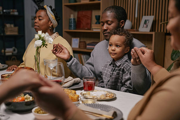 Family praying at the table before eating
